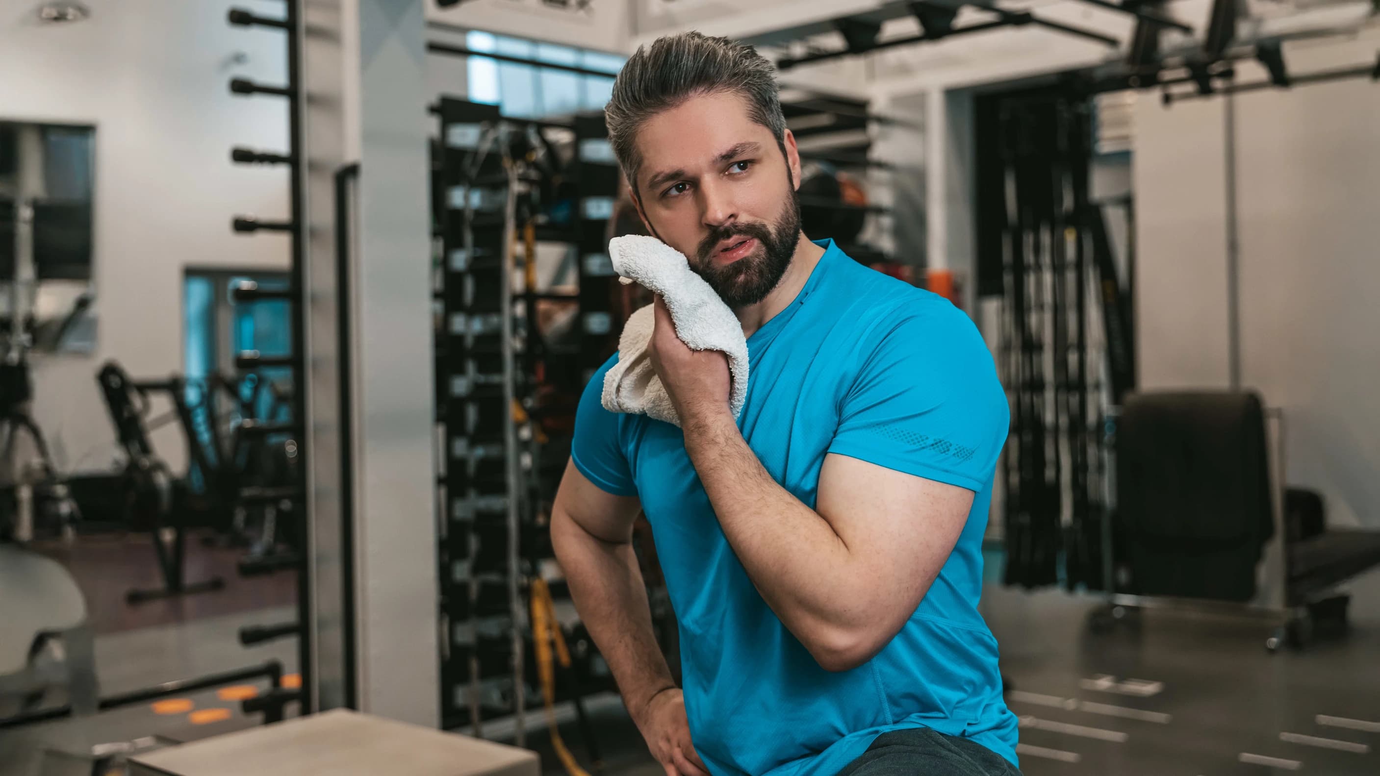 Man in gym holding a So Fresh wet towel after a workout